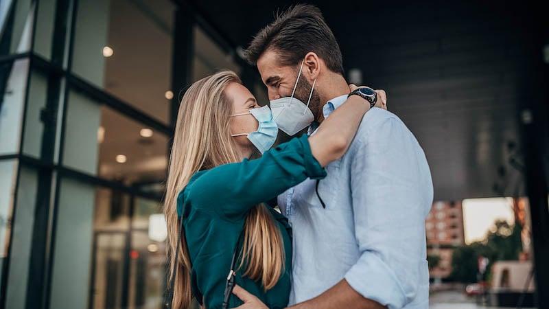 Couple kissing with masks
