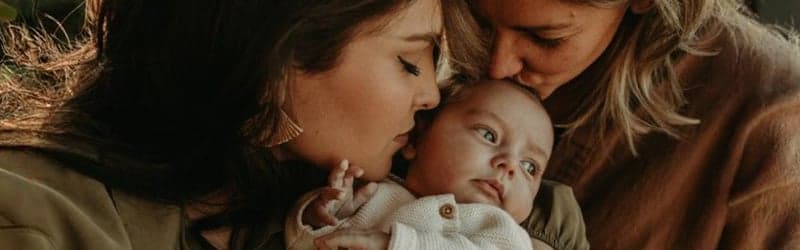 Parents lesbiens embrassant leur enfant Parents lesbiens embrassant leur enfant