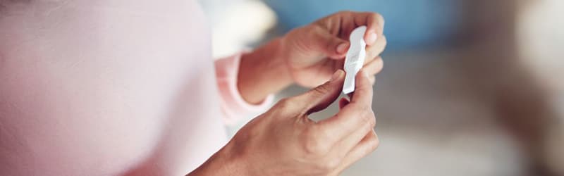 Woman looking at a positive pregnancy test Woman looking at a positive pregnancy test