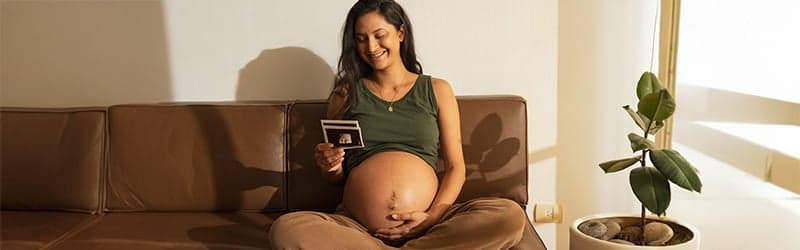 Pregnant woman sitting on her couch Pregnant woman sitting on her couch