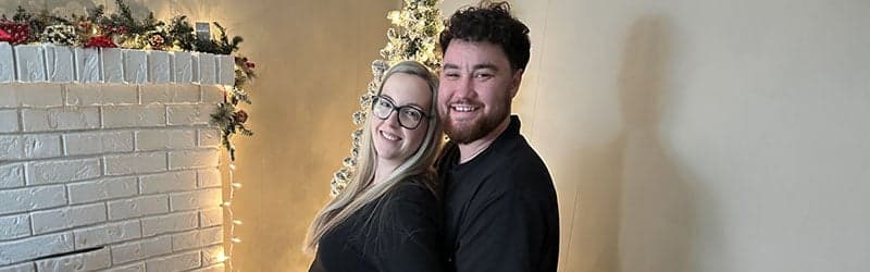 Aaron and Kayla in front of a Christmas tree Aaron and Kayla in front of a Christmas tree