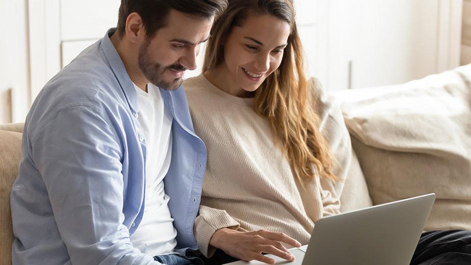 Couple avec un ordinateur calculant le prix d’ovules de donneuse de Cryos