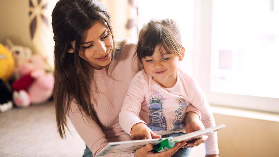 Moeder en dochter die een kinderboek lezen over donorconceptie Moeder en dochter die een kinderboek lezen over donorconceptie