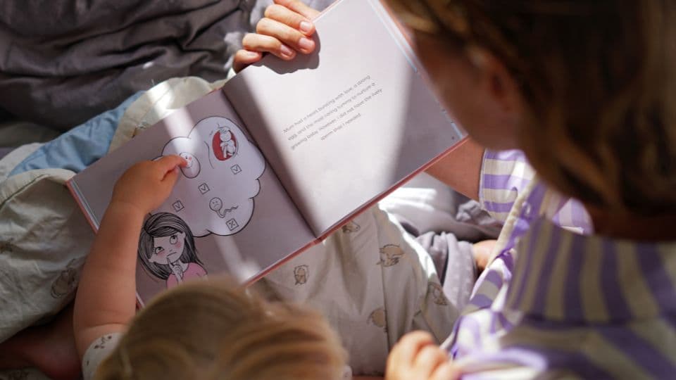 Mother and child reading Cryos’ children’s book about donor conception Mother and child reading Cryos’ children’s book about donor conception