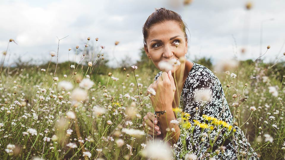 Young woman in flower field considering egg freezing at Cryos 