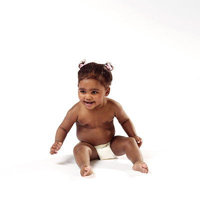 Schwarzes weibliches Baby sitzt aufrecht, weißer Hintergrund – Foto aus der Cryos-Pressemappe.