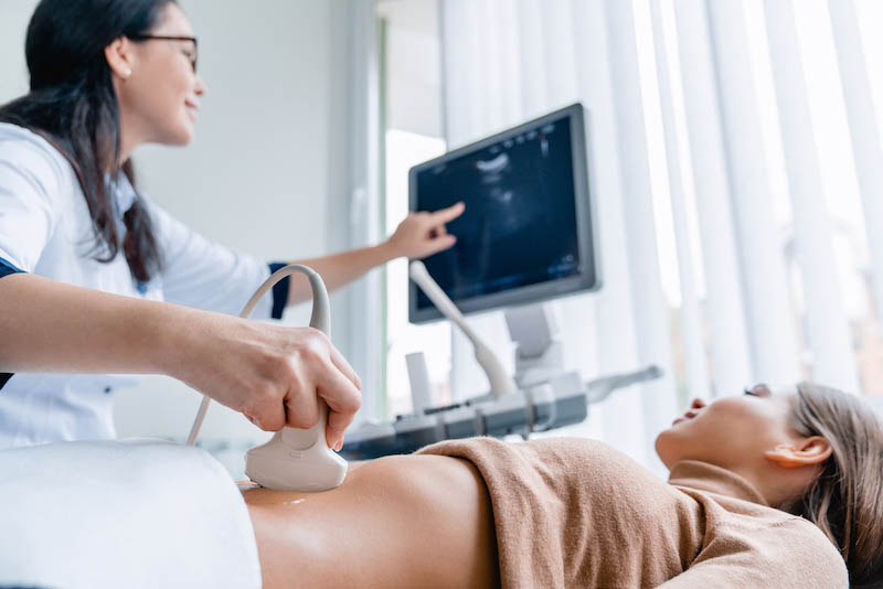 Frau bei einer Ultraschalluntersuchung nach einer IVF-Behandlung