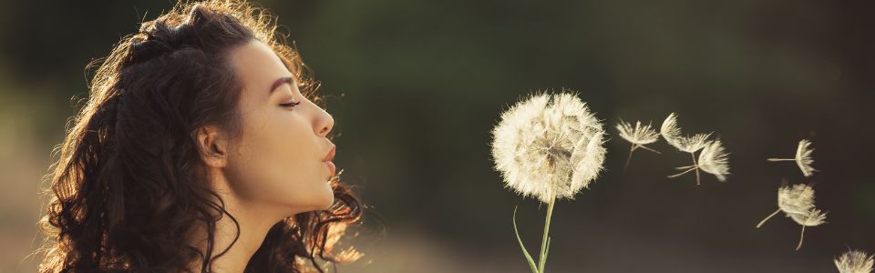 Woman with dandelion – thinking about becoming an egg donor