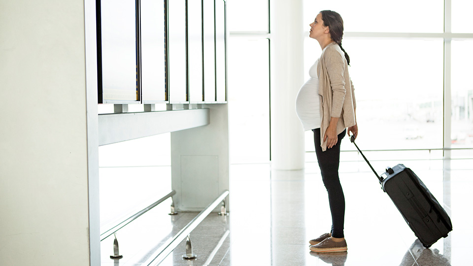 Une femme avec une valise, voyageant à l’étranger pour suivre un traitement de fertilité