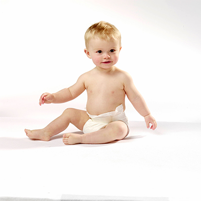 Een wit babyjongetje zit rechtop tegen een witte achtergrond – Foto uit de Cryos-persmap. 