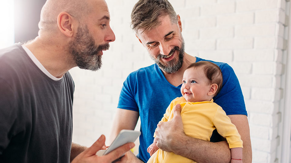 Same-sex parents with their baby conceived with donor egg and the help of a surrogate.
