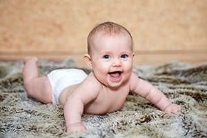 Een lachende baby op een deken – Foto uit de Cryos-persmap. 
