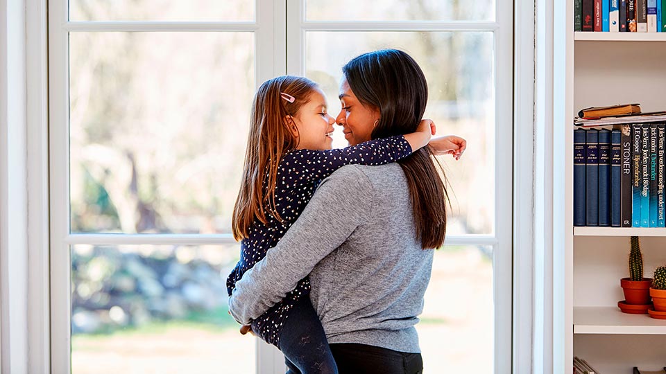 Mulher solteira por opção a abraçar a sua filha concebida através de um doador