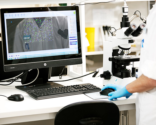 Funcionário do laboratório da Cryos examinando o esperma de um doador