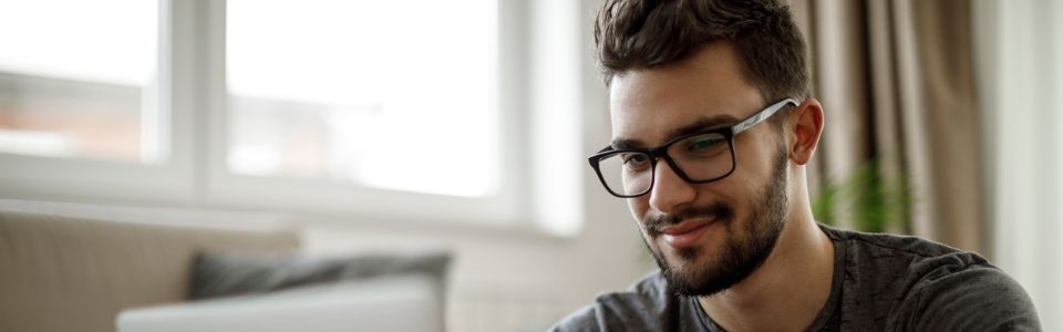Young man with laptop applying to become a sperm donor