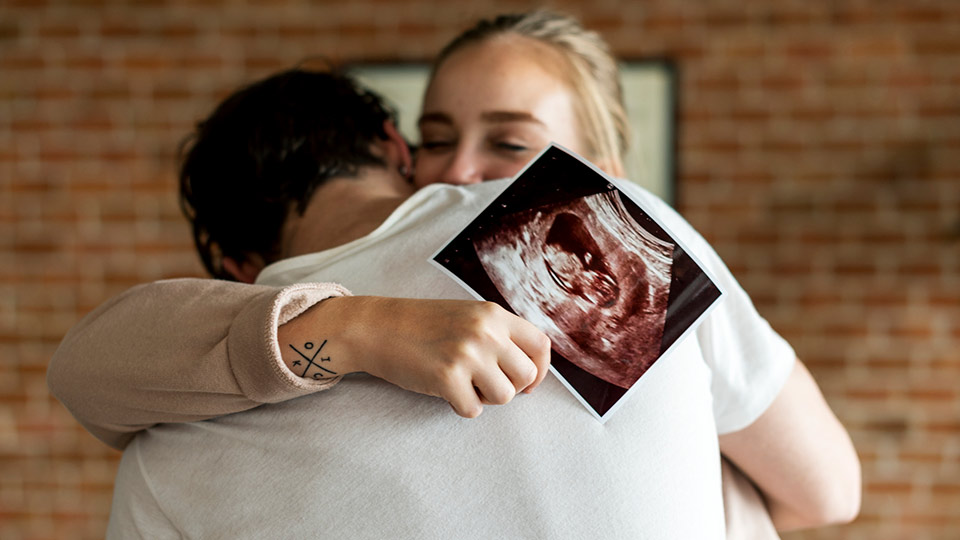 Man and woman happy about pregnancy after ICSI (IVF) fertility treatment with donor eggs