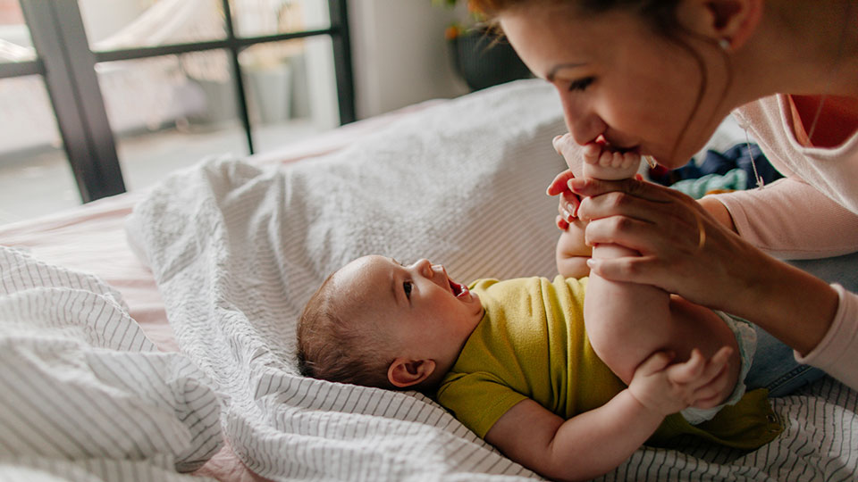 Mère heureuse embrassant son bébé après avoir choisi une donneuse d’ovules pour son traitement de fertilité