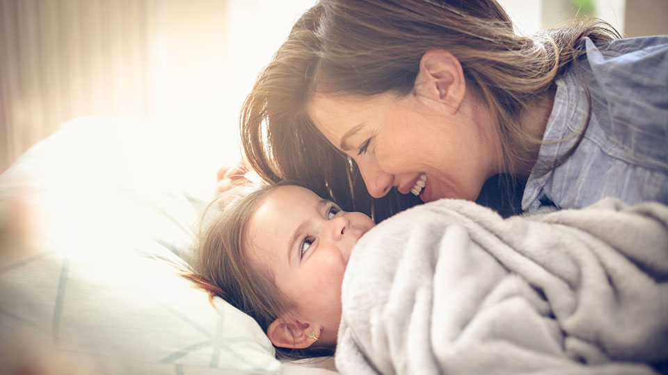 Une mère et sa fille dans un lit parlant d’un contact possible avec une donneuse d’ovules