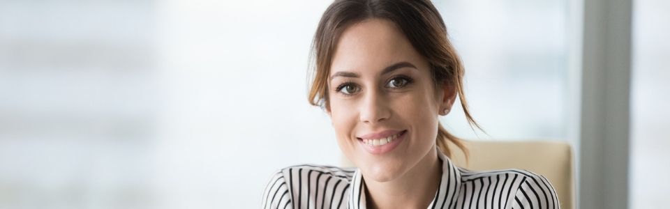 An egg donor sitting in a office and smiling