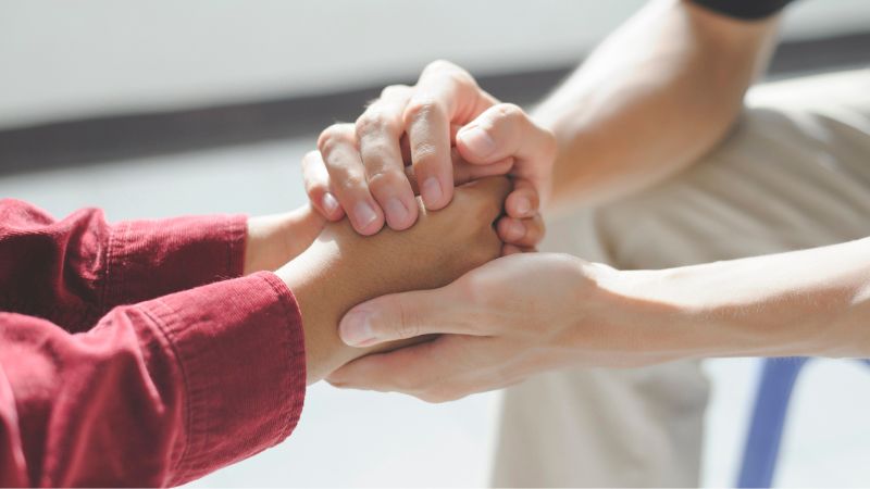 Couple holding hands and grieving