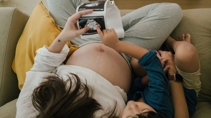 写真を見ている妊婦