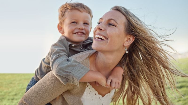 Mère célibataire par choix et enfant jouent ensemble dans un champ Mère célibataire par choix et enfant jouent ensemble dans un champ