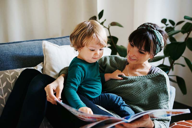 Madre leyendo un libro a su hijo concebido con esperma de donante