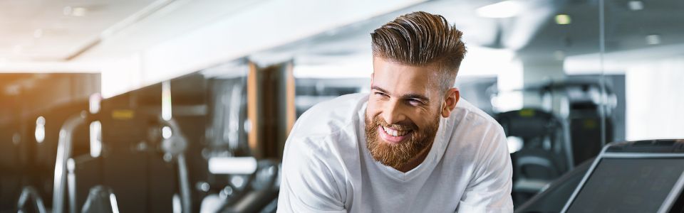 Mand der smiler på et løbebånd
