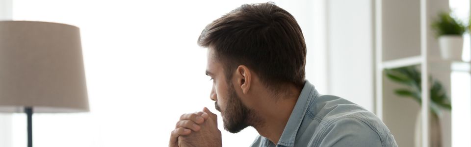 Een man die verdrietig kijkt vanwege vruchtbaarheidsproblemen
