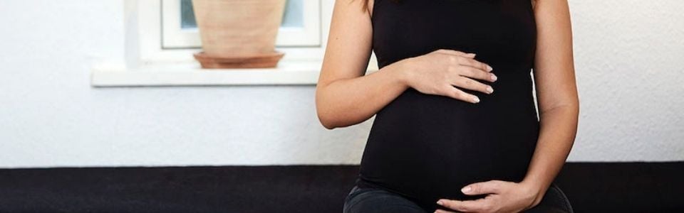 A pregnant woman holding her hands around her belly