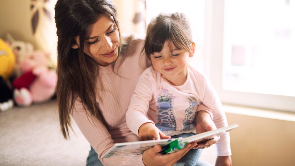 Mother reading donor child’s book about donor conception to her daughter  