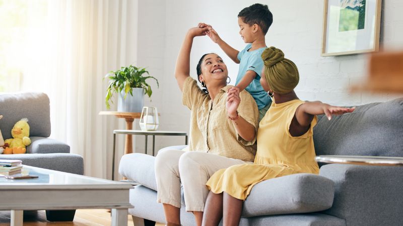 Lesbian couple and their child playing in their living room Lesbian couple and their child playing in their living room