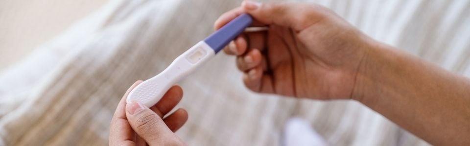 Woman holding a positive pregnancy test Woman holding a positive pregnancy test