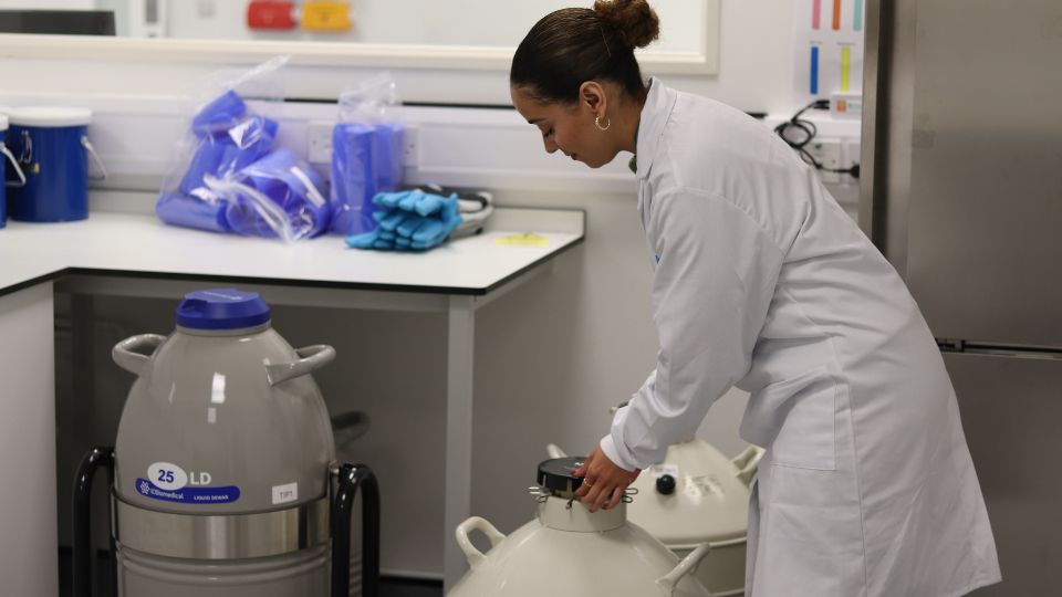 Lab worker with a cryo tank Lab worker with a cryo tank